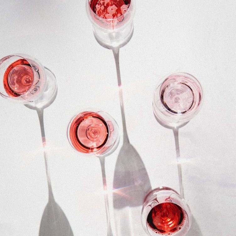 Zwei Personen stoßen mit Weingläsern in einem festlichen Ambiente an.